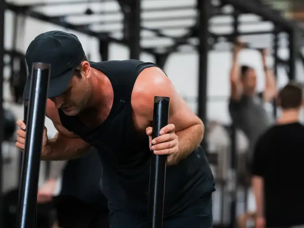 Cube Gym member pushing a weighted sled during a conditioning session